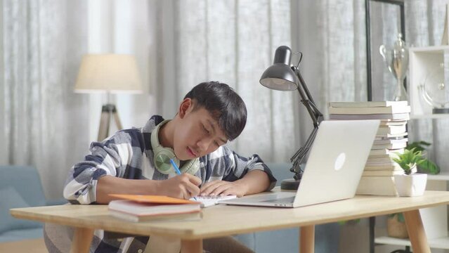 Asian Teenager Learning Online From Laptop At Home
