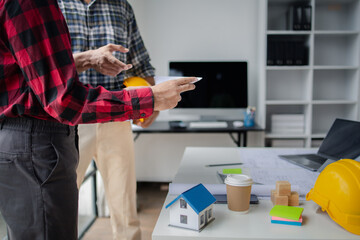 The home design architects are reviewing the house plan draft, the project commissioned by the client, and the custom design before delivery. Interior design and decoration ideas.