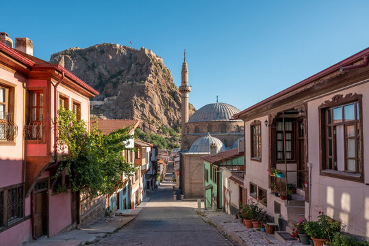 Traditional Turkish Ottoman houses in Afyonkarahisar Turkey. Afyon Castle on the rock and Mevlevihane Museum in front of it