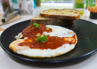 Breakfast plate with eggs, toast, and tomato sauce