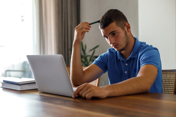 Teenage boy using laptop and doing homework