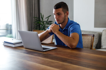 Teenage boy using laptop and doing homework