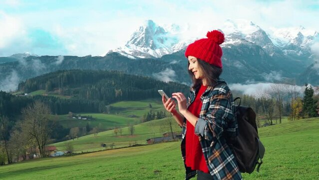 Pretty smiling asian woman girl hiking equipment walk in mountain alps, looks around, take photo on mobile phone, enjoy beauty nature and walk Alpine meadow Hiking, hobby, relaxation, recreation time