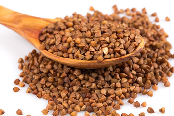 Uncooked buckwheat on wooden spoon