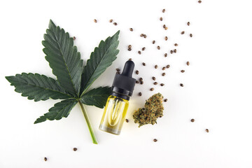 A green fresh leaf of medical marijuana, next to it is a glass bottle of cbd oil extract with a...