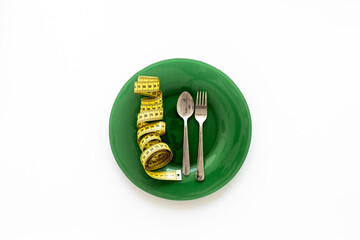 Empty plate with cutlery and tape measure for body weight control, top view