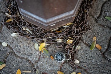Top view of metal chains lying on the ground tied with of a numeric lock