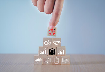 The idea of organizing a business plan Businessman selecting a target wooden block business process...