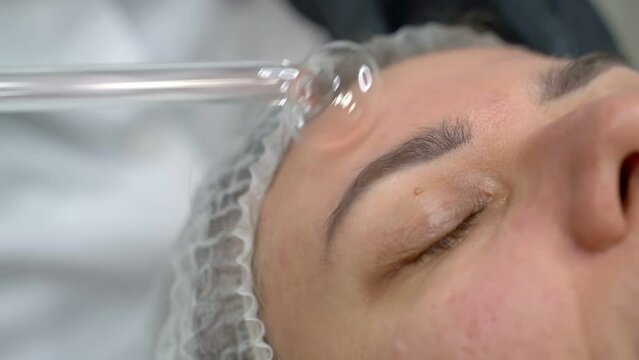 Relaxed girl at beautician clinic during facial stimulation procedure with darsonval device after professional facial skin cleansing Stimulation of regeneration and pro-inflammatory procedure. Video