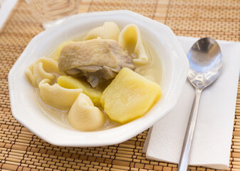 Chicken broth soup with chicken, potatoes, and pasta shells