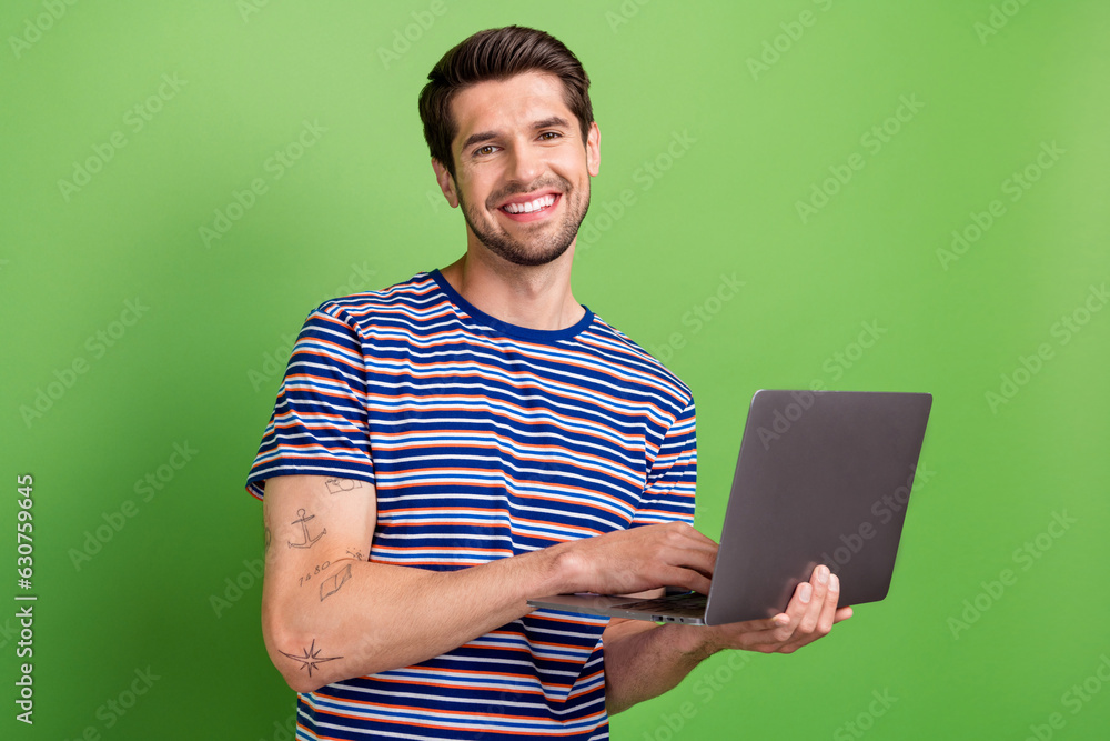 Aufkleber Photo of positive young man experienced netbook user program developer freelancer using gadget isolated on green color background