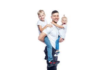 Happy handsome man with small children in his arms. Dad with son and daughter in faded t-shirts and jeans. Love and tenderness. Isolated on a white background.