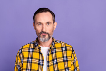 Photo of candid sincere serious man with white gray beard wear yellow plaid shirt look at camera isolated on purple color background