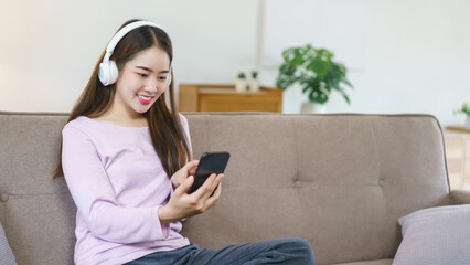 Women wearing headphone to listening the music and chatting on smartphone in lifestyle at home