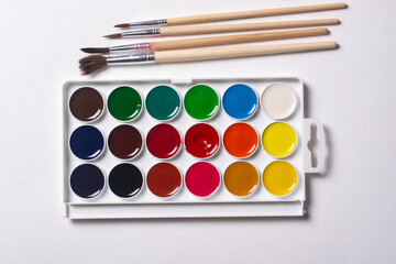 Watercolor paints and brushes, top view.