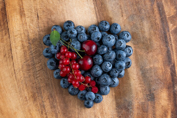Blueberry heart on a wooden background. Summer background.