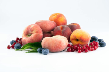 Blueberries, red currants and peaches on a white background.