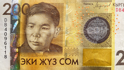 Top view of the yellow 200 som bill. Portrait of poet and playwright Alykul Osmonov. The current money of Kyrgyzstan. Economics and finance. Two hundred som