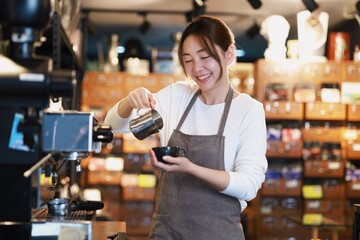 Cheerful woman making a coffee cup in cafe,Barista holding a cup of hot coffee for the first Morning.