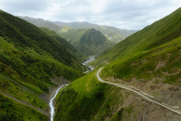 Fototapeta na wymiar Kazbegi region, Georgia, picturesque mountain landscape wiht Chauhi River and Caucasus mountain range, Juta valley. High quality photo