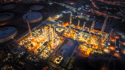 Aerial view of the petrochemical, oil and gas industry. Industrial field, oil refinery storage tanks and steel pipelines at night, ecology and health.