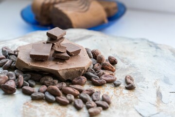 Closeup of tasty milk chocolate on a rocky surface with some coffee beans