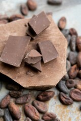 Closeup of tasty milk chocolate on a rocky surface with some coffee beans