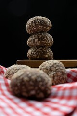 Stack of freshly baked small buns on a wooden board and checkered red tablecloth