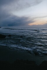 Moody sunset photo of the ocean from the Pacific Coast Highway with rich blue and purple colors.