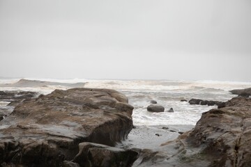 Rainy day shot of the ocean from the Pacific Coast Highway with overcast skies and roaring waves
