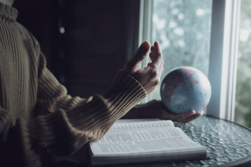 Man holding the globe and praying for people around the world.