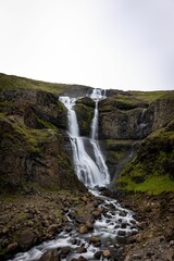 Obraz premium Vibrant Rjukandi waterfall cascading down a lush green hillside