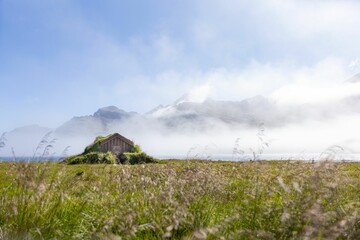 Troll's house in Iceland in Stodvarfjordur with grass fog and mountains