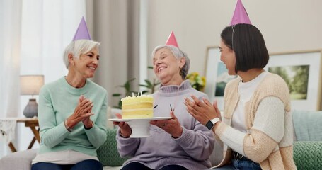 Birthday party, cake or wow and senior woman making a wish with friends in the home living room to blow out candles. Celebration, applause or milestone with an old person enjoying a retirement event