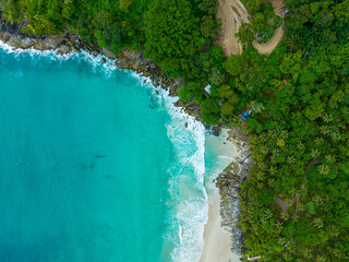 .aerial top view amazing freedom beach small white sand beach with perfect nature. .white wave hit the rock around island. .green forest peaceful. green sea, and clear sand landscape. Paradise beach..