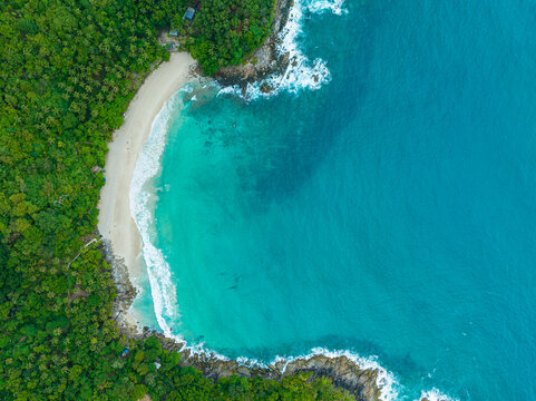 .aerial top view amazing freedom beach small white sand beach with perfect nature. .white wave hit the rock around island. .green forest peaceful. green sea, and clear sand landscape. Paradise beach.. © Narong Niemhom