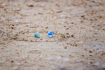 High-resolution photograph of two white and grey marble balls resting on the ground