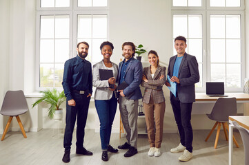 Multi ethnic group of successful confident office workers professional experts stand in row one...