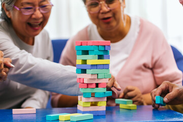 Senior people playing a wooden block tower, risk and strategy of project management. Concept of...