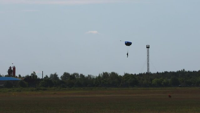 Skydiving. The parachutist lands on the ground
