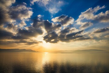 Obraz premium Idyllic seascape featuring a vibrant sunset over a tranquil bay, with tranquil blue waters