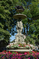 Fototapeta premium Langrune-Sur-Mer, France - 07 18 2023: View of the fountain of the three graces in the park of the town hall of Langrune-Sur-Mer