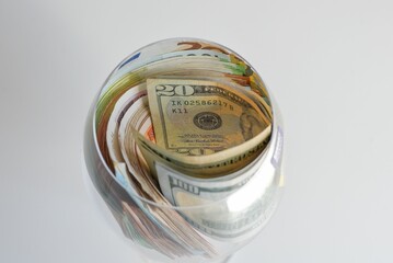 Close up of a cup filled with different money bills © Lucija Kanižaj/Wirestock Creators