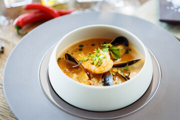 Shrimp Bisque with Seafood. King prawn, blue mussels, cod, whipped cream. Delicious traditional food closeup served for lunch in modern gourmet cuisine restaurant