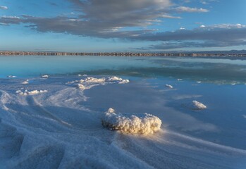 Landscape of a frozen lake under the sunlight and a blue cloudy sky