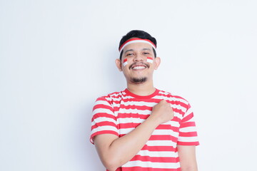 Indonesian man looking to the camera with hand on chest showing proud gesture, celebrating Indonesia independence day.