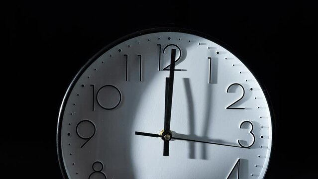 Timelapse of the time passing fast with the clock isolated on the empty black background