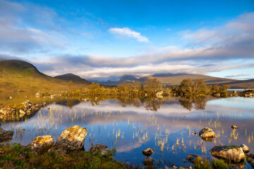 Loch na h-Achlaise, Rannoch Moor, Scotland, on a beautiful early autumn morning. Leaves are turning but are still on trees.