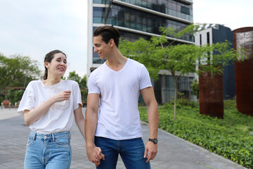Obraz premium Beautiful young couple in love walking outdoors at the city street