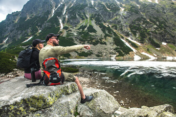 Couple of tourists in the mountains. mountain lake. The theme of sport and recreation in the mountains.